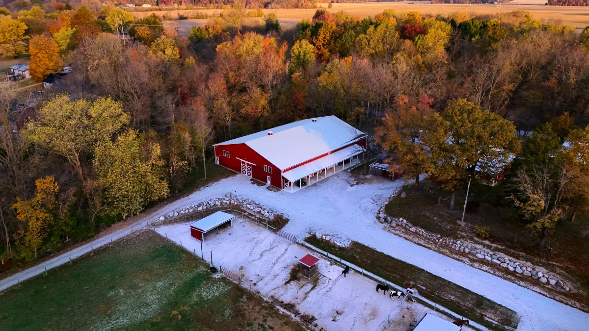 A large red barn is shown from above in stellar lighting with dramatic shadows